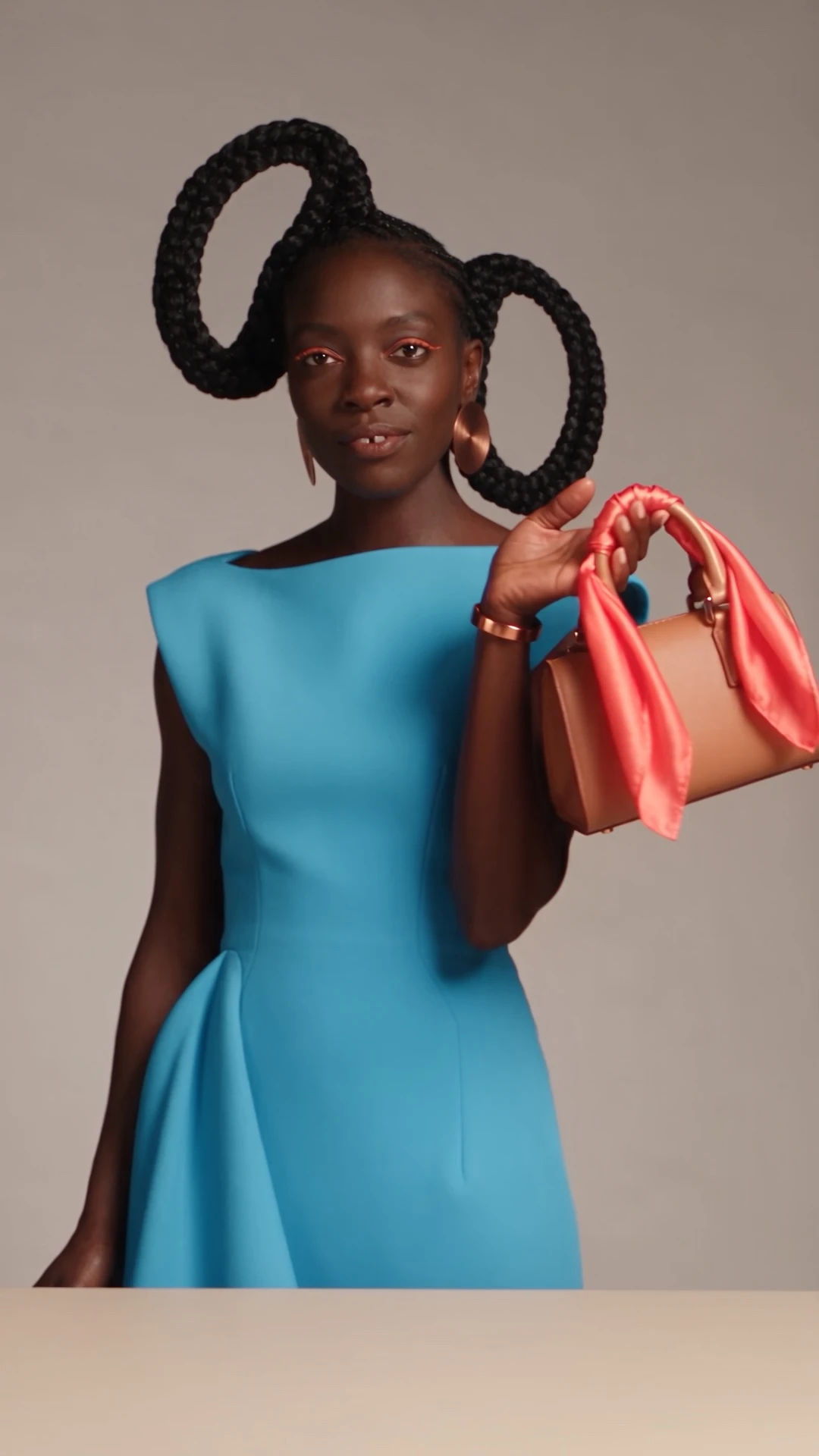 Un creador styles un bolso con un pañuelo de seda.